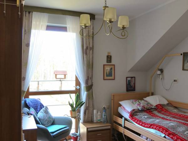 Pflegerin und Seniorin in herzlicher Umarmung