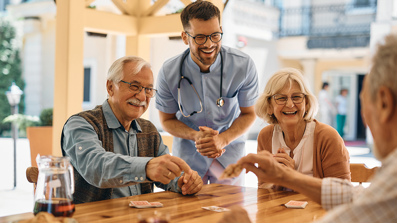 Pflegerin unterstützt Senior liebevoll